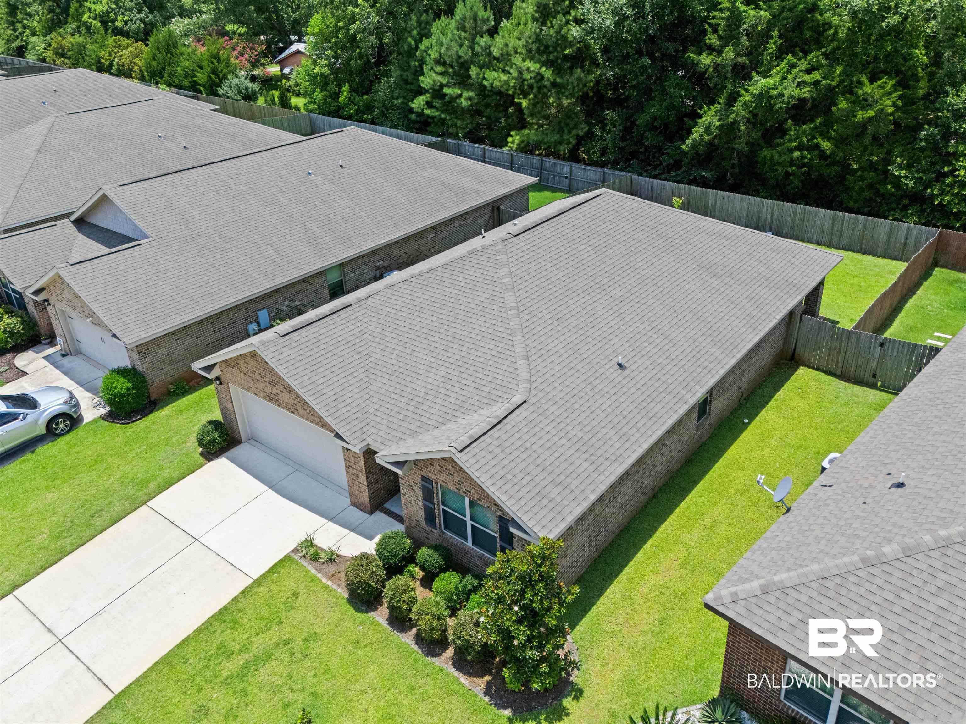 Image 3: Aerial perspective showcasing a single-story brick exterior residence with an attached garage and a concrete driveway