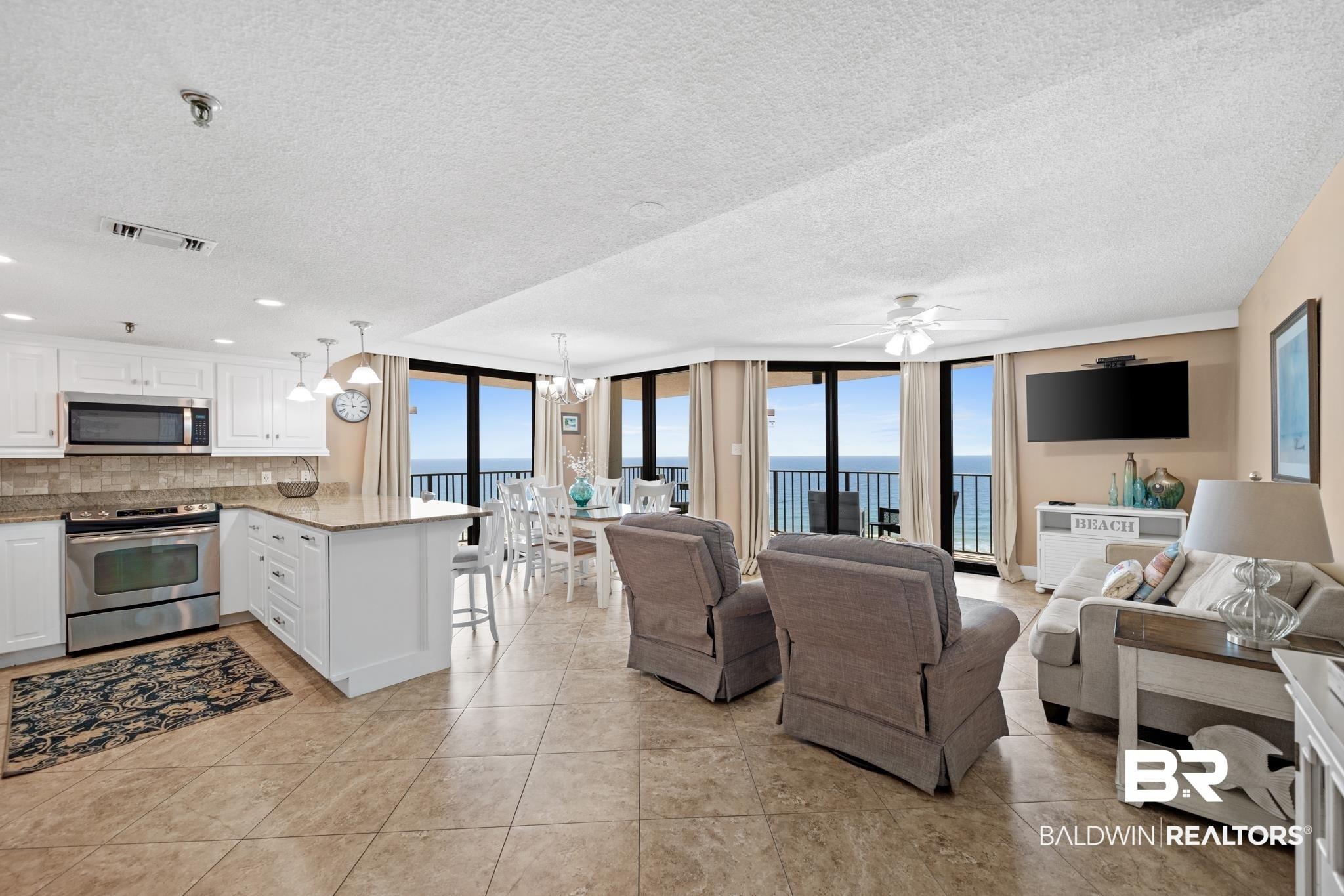 Image 3: Open-concept living area with tile flooring and panoramic exterior views