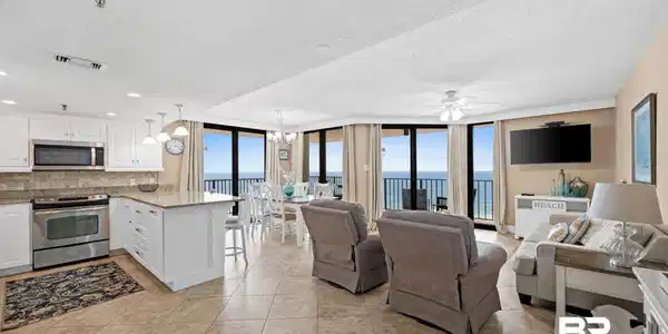 Image 3: Open-concept living area with tile flooring and panoramic exterior views