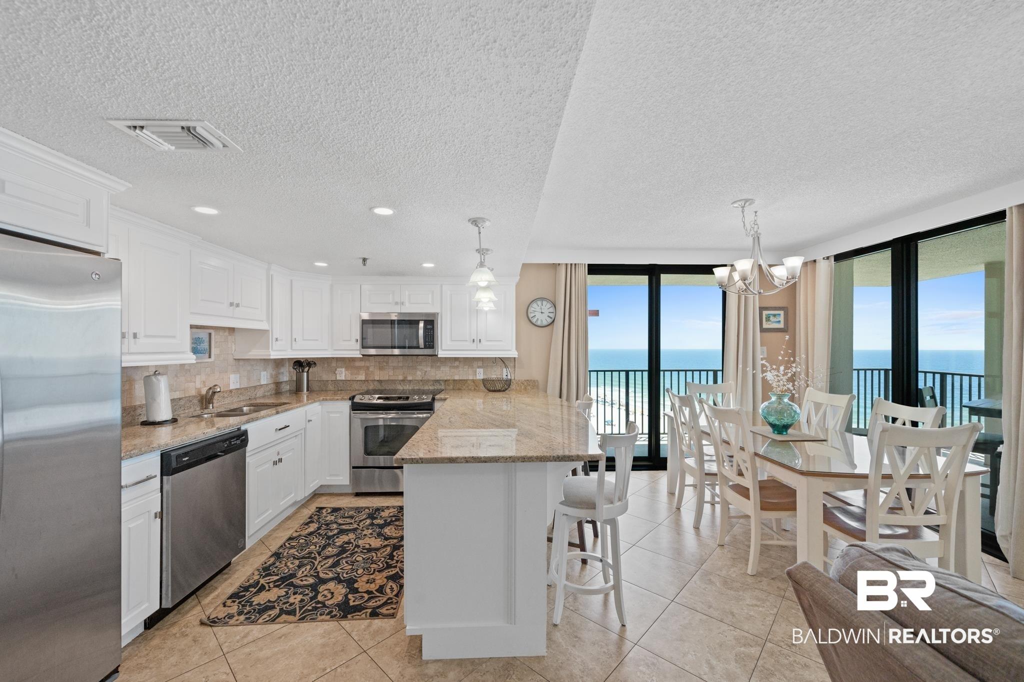 Image 4: Open concept kitchen and dining area with expansive ocean scenery