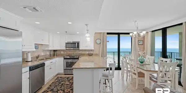 Image 4: Open concept kitchen and dining area with expansive ocean scenery