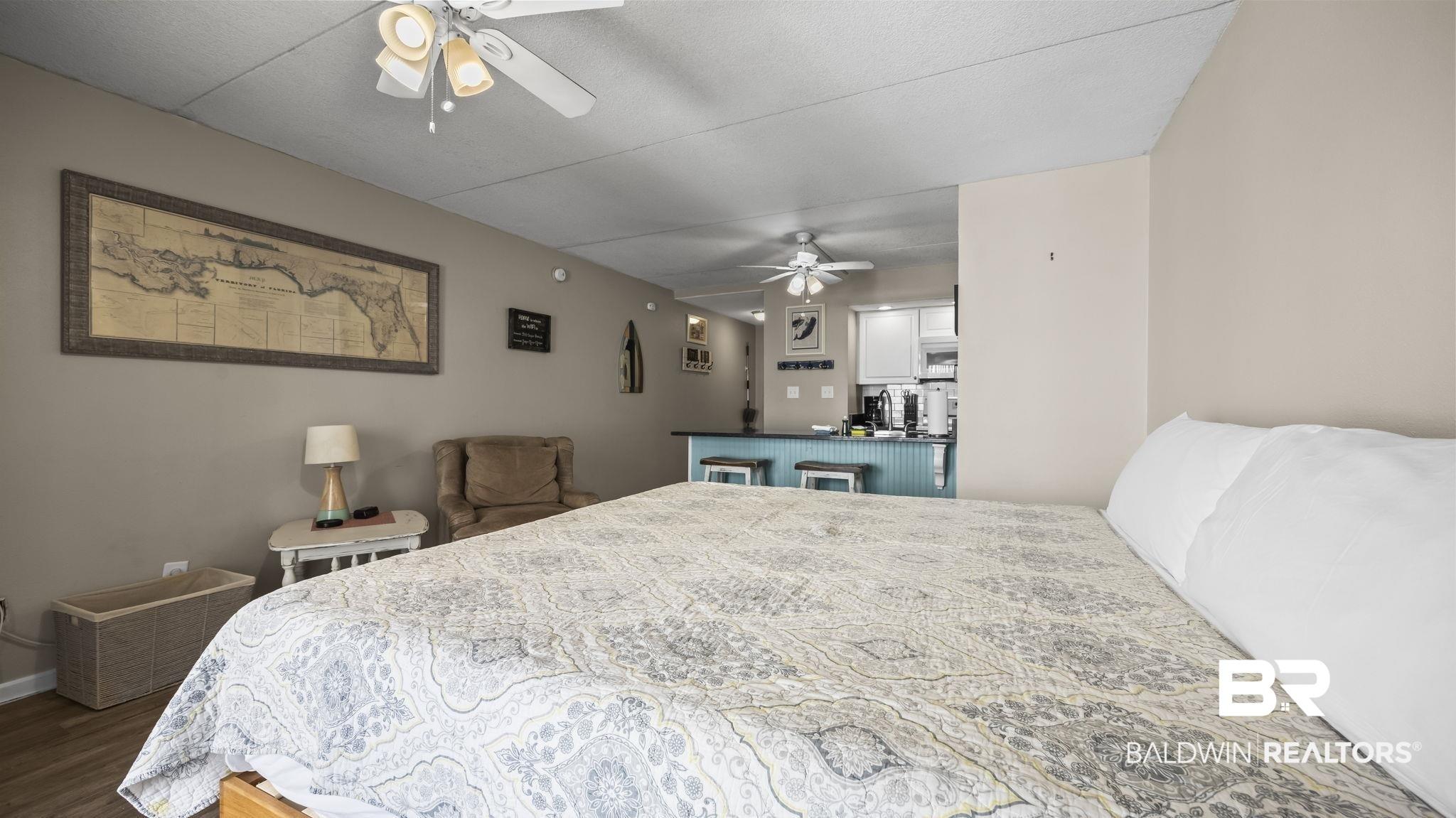 Image 2: Open-concept living space featuring wood-finish flooring and a neutral color palette
