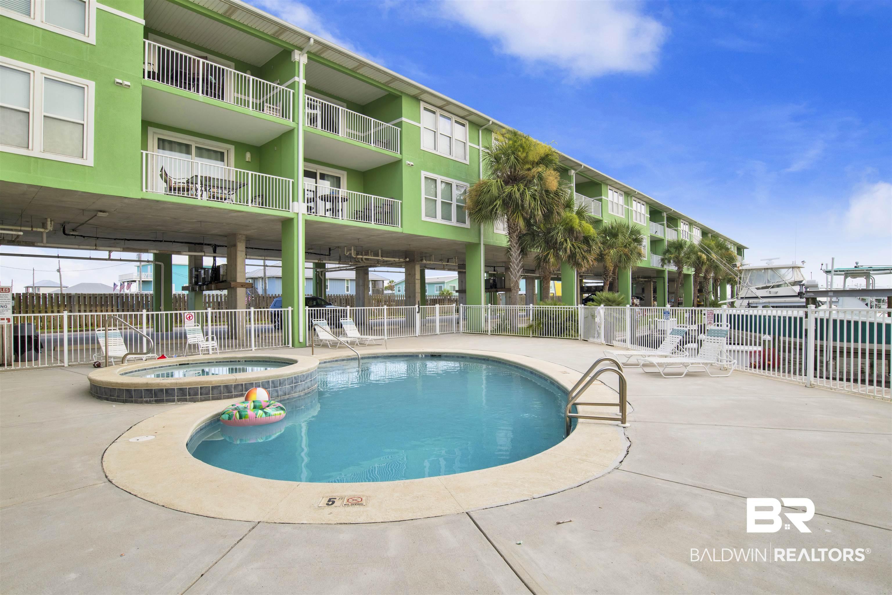Image 4: Community pool with a community hot tub and a patio
