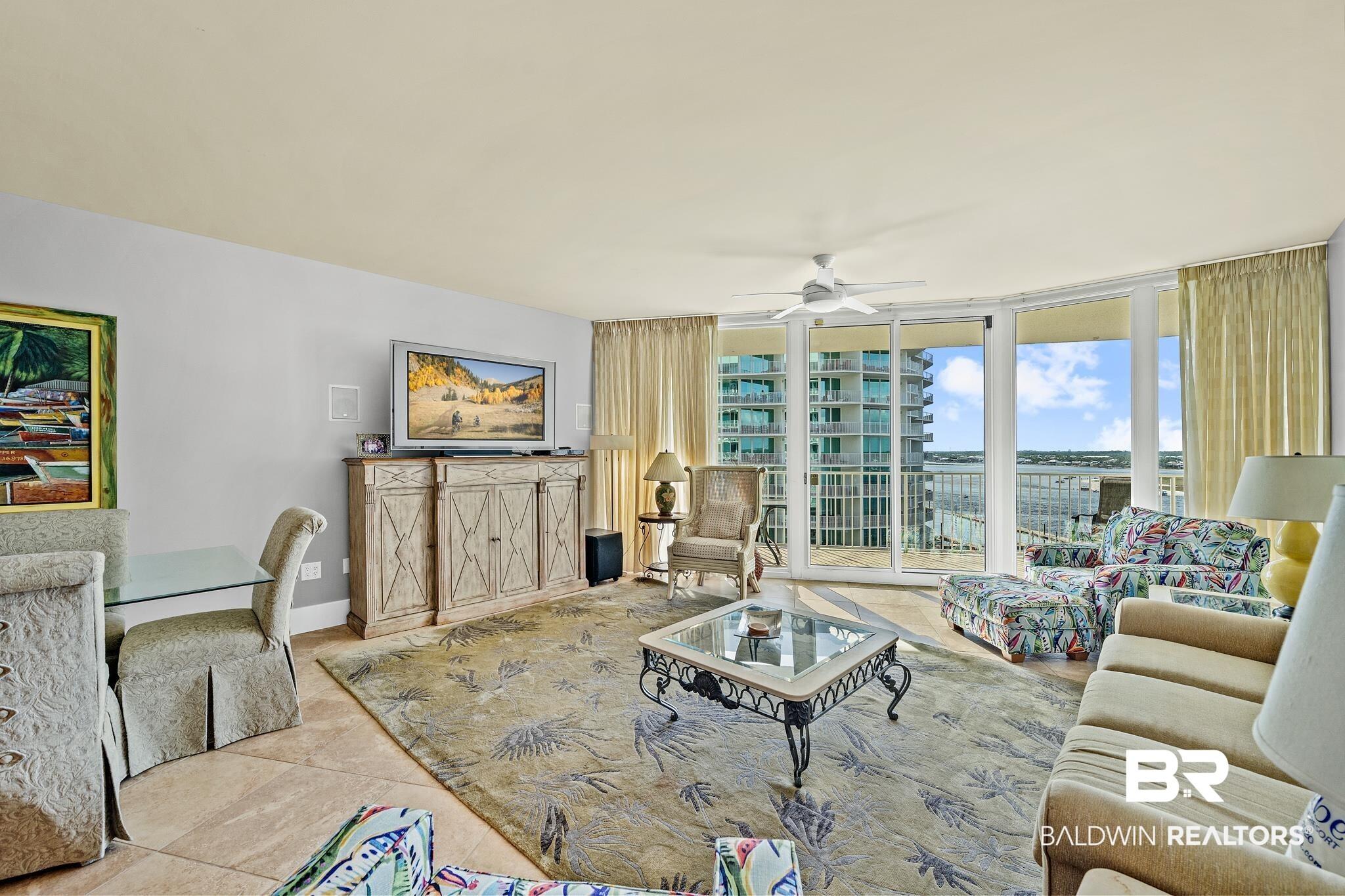 Image 3: Expansive living area featuring tile flooring, a built-in media console, and a ceiling fan