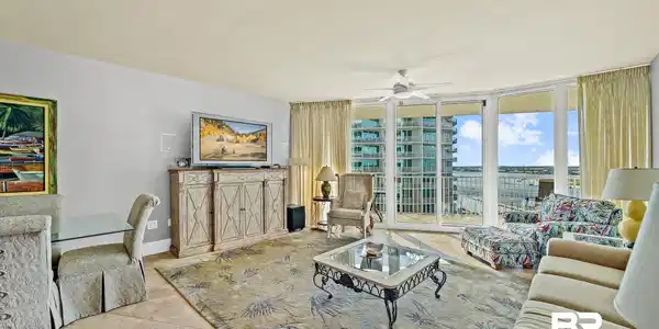 Image 3: Expansive living area featuring tile flooring, a built-in media console, and a ceiling fan