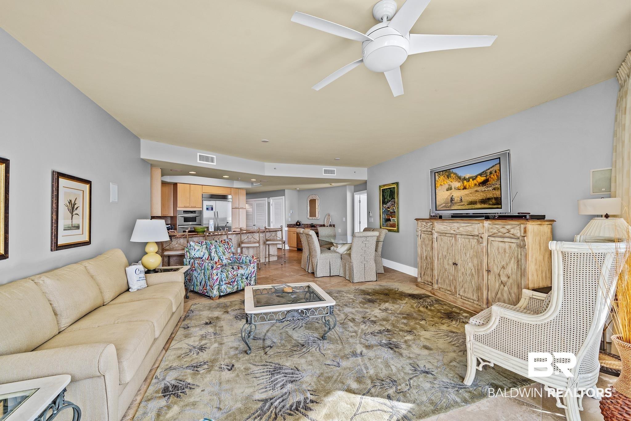 Image 4: Open-concept living space featuring a ceiling fan, recessed lighting, and tile flooring