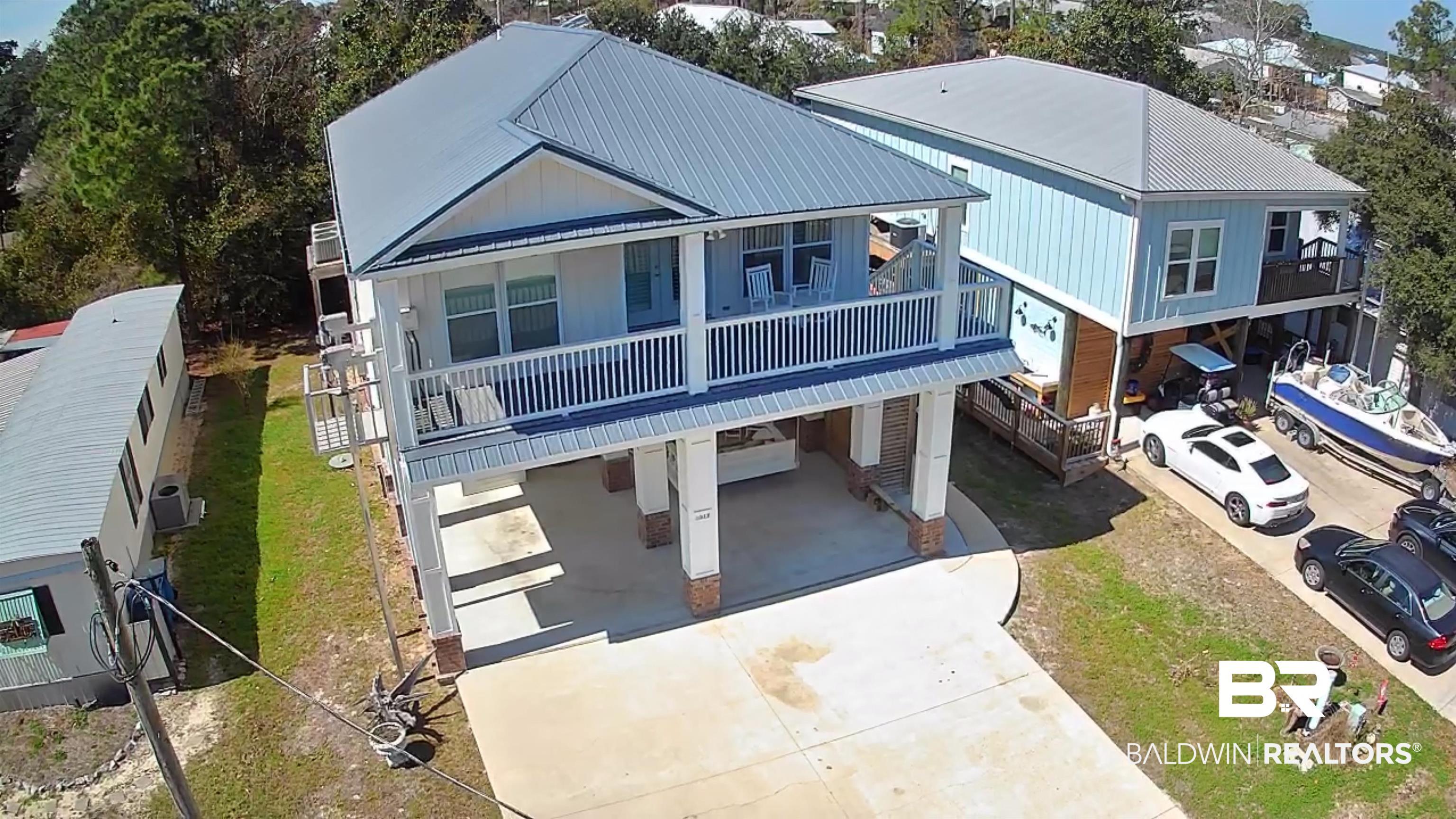 Image 3: View of front of home featuring a carport, a metal roof, and driveway