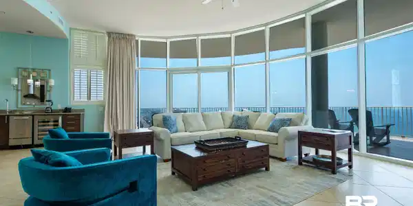 Image 2: Living room featuring expansive windows, light tile patterned floors, wine cooler, and ceiling fan