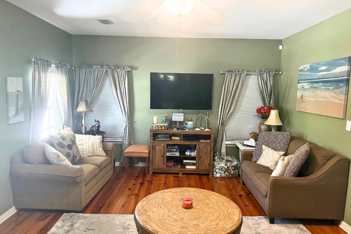 Image 4: Living area with wood finished floors and a ceiling fan