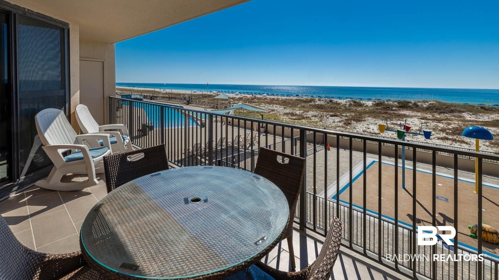 Image 4: Balcony featuring outdoor dining space and view of water and beach
