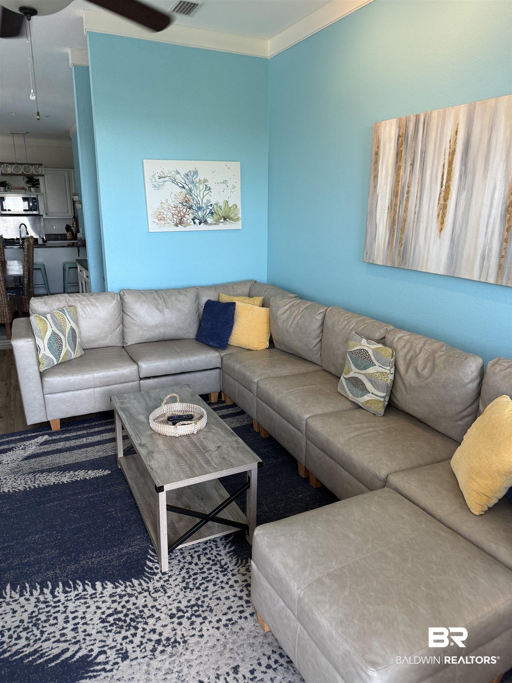 Image 4: Open-concept living space with light blue walls and crown molding