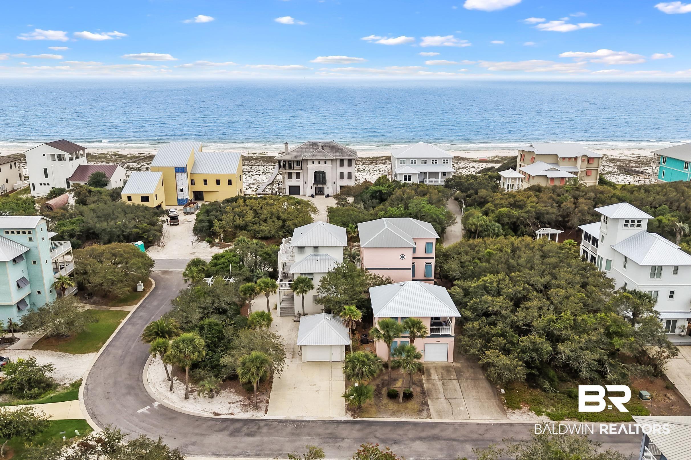 Image 2: Coastal neighborhood featuring multiple properties, direct beach access, and mature natural landscaping