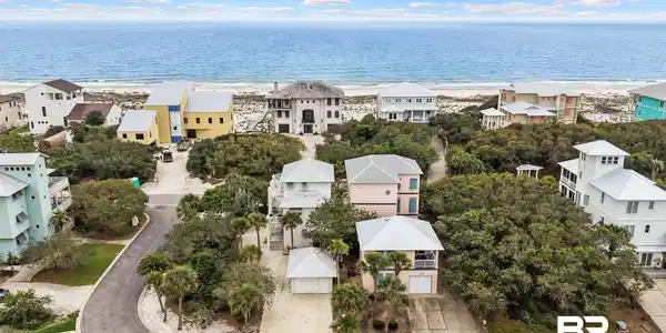 Image 2: Coastal neighborhood featuring multiple properties, direct beach access, and mature natural landscaping