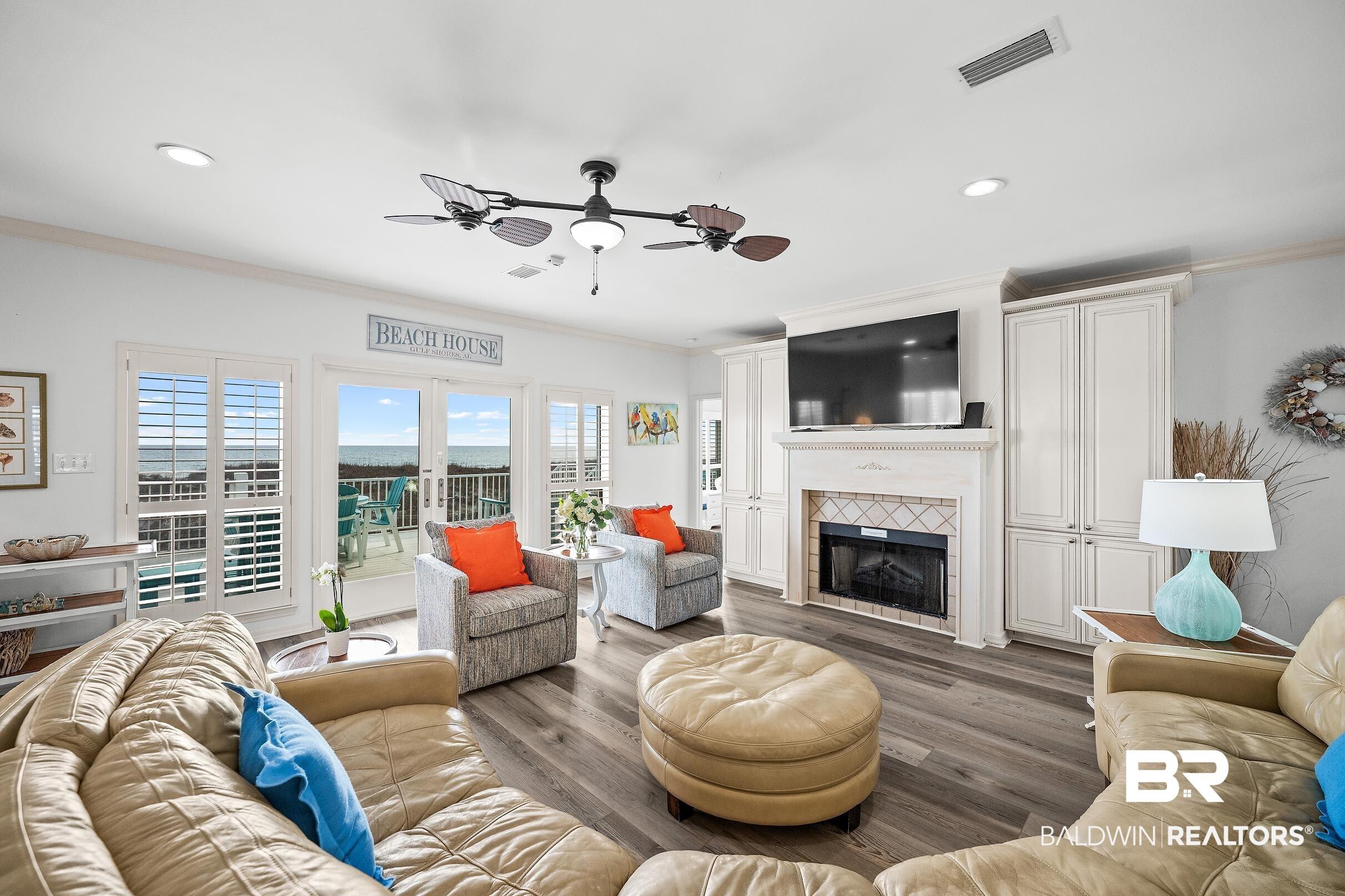 Image 4: Living room with a ceiling fan, wood finished floors, ornamental molding, a tile fireplace, and french doors