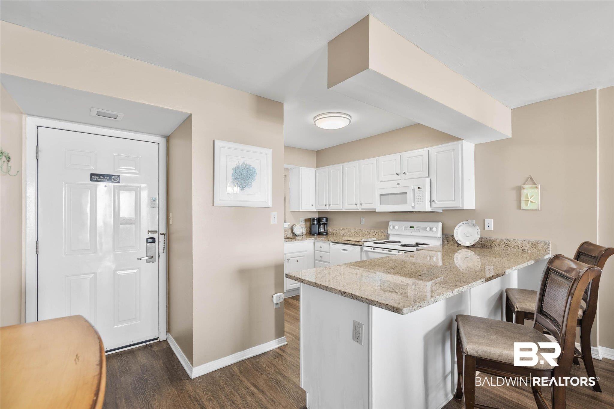 Image 3: Entryway and kitchen featuring wood-finish flooring