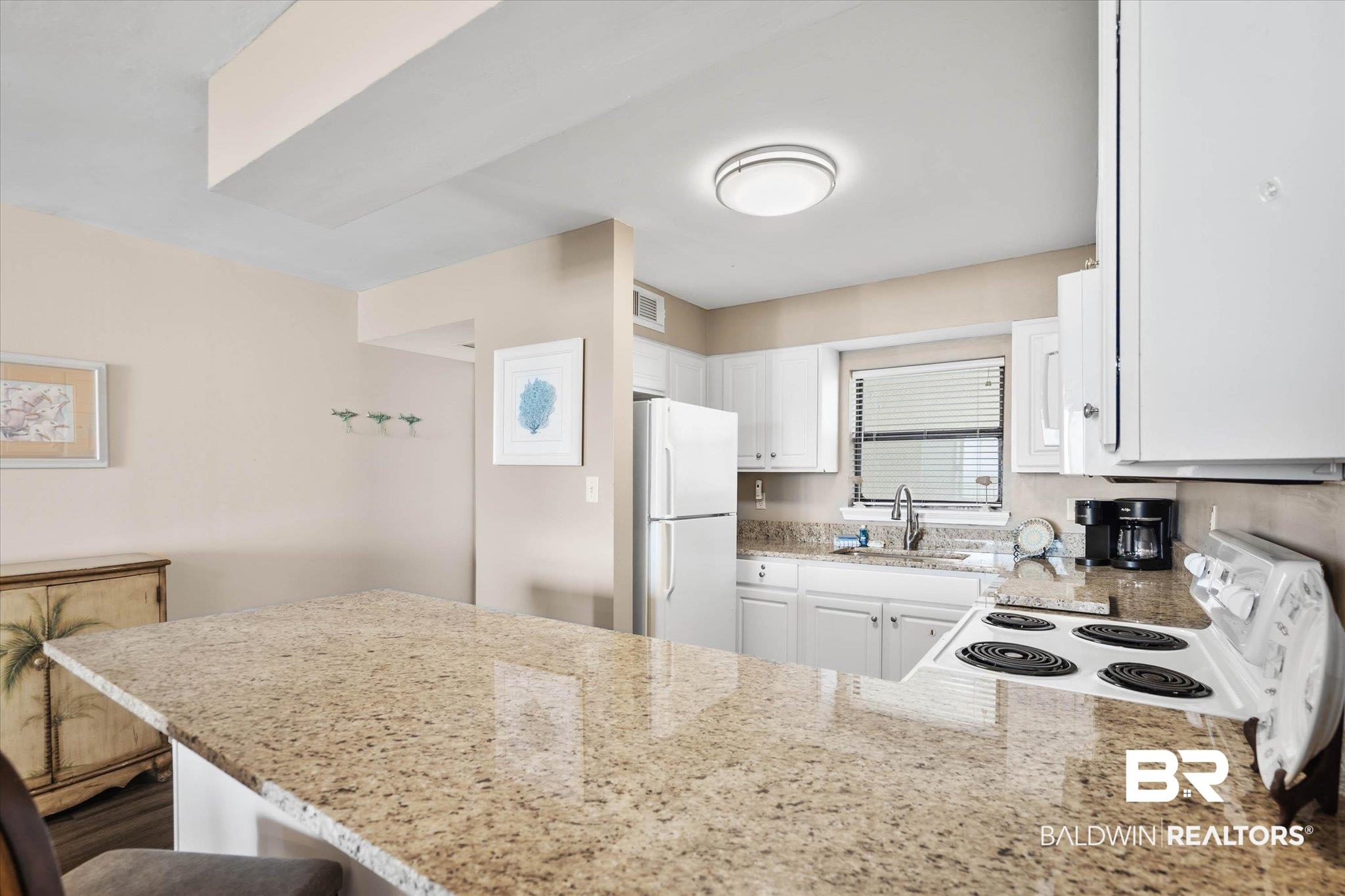 Image 4: Kitchen featuring white cabinetry, granite countertops, and a full suite of white appliances