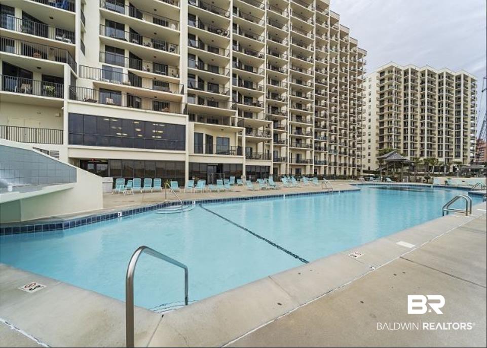 Image 2: Expansive outdoor swimming pool with a concrete surround and integrated steps