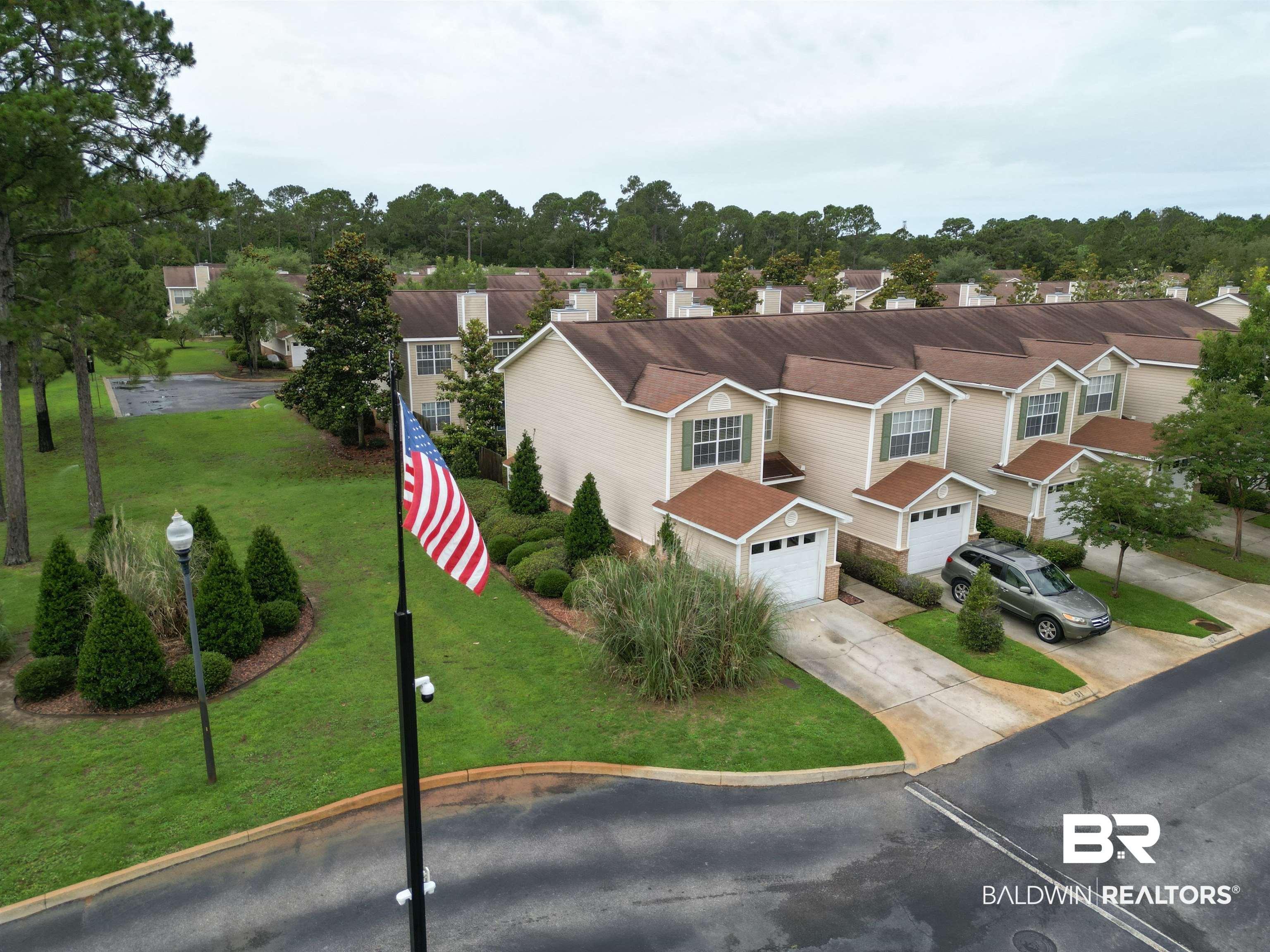 Image 2: Townhome community featuring neutral-toned siding, attached garages, and individual driveways