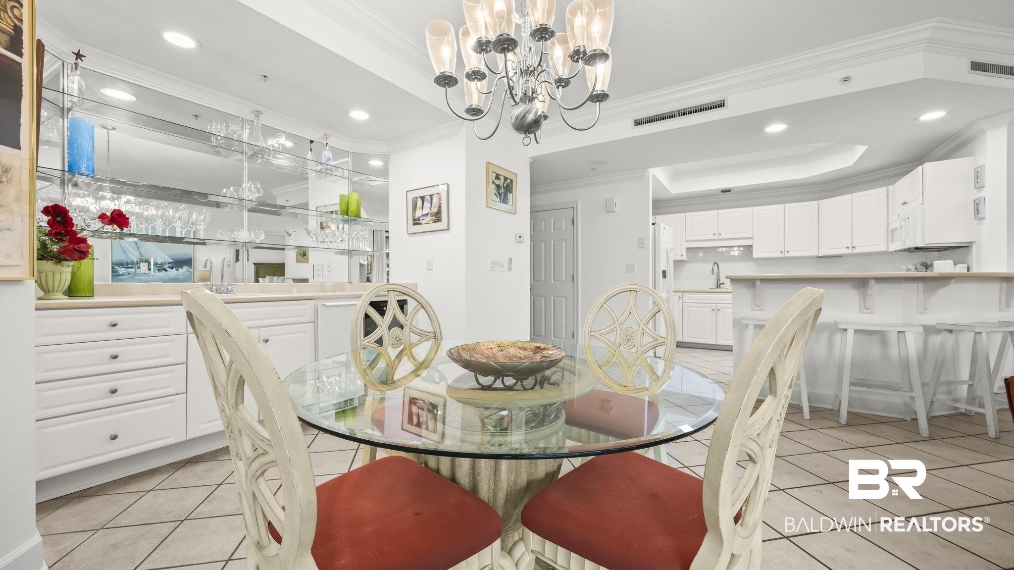 Image 4: Dining area featuring a contemporary chandelier and tile flooring