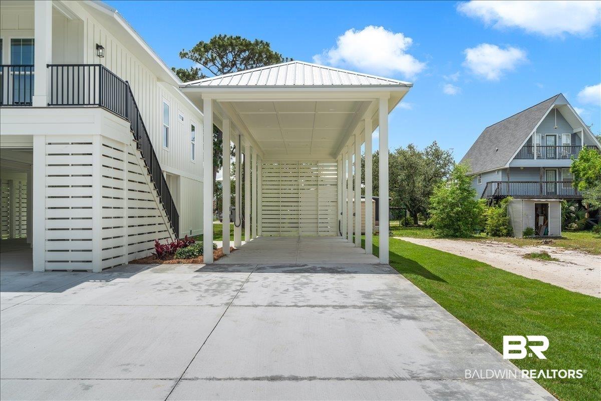 Image 3: Covered carport featuring a white metal roof and slatted side paneling