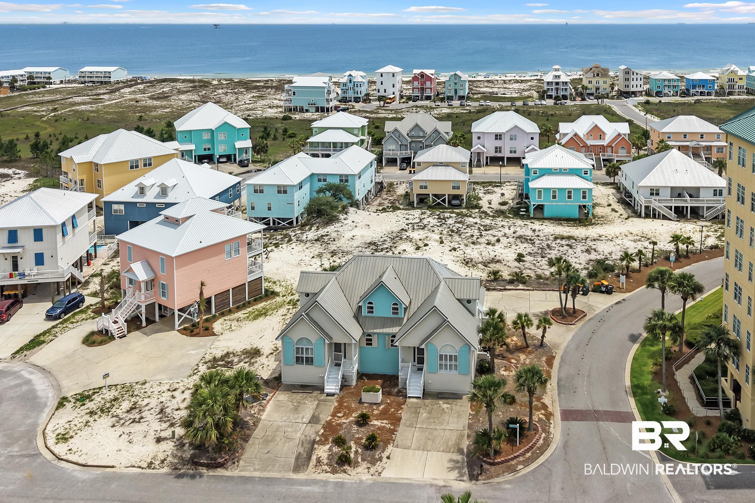 Image 4: Coastal duplex featuring light blue siding, white trim, and a prominent front entrance
