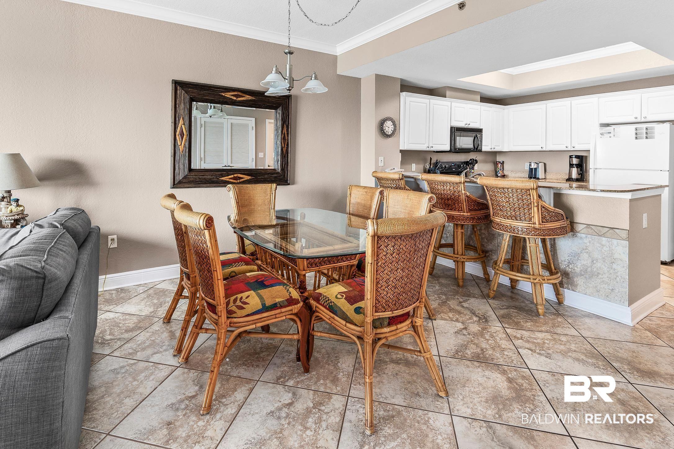 Image 4: Open-concept dining and kitchen areas featuring tile flooring throughout