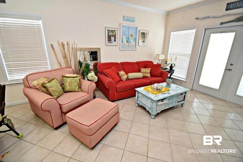 Image 2: Living room featuring light tile patterned floors and crown molding