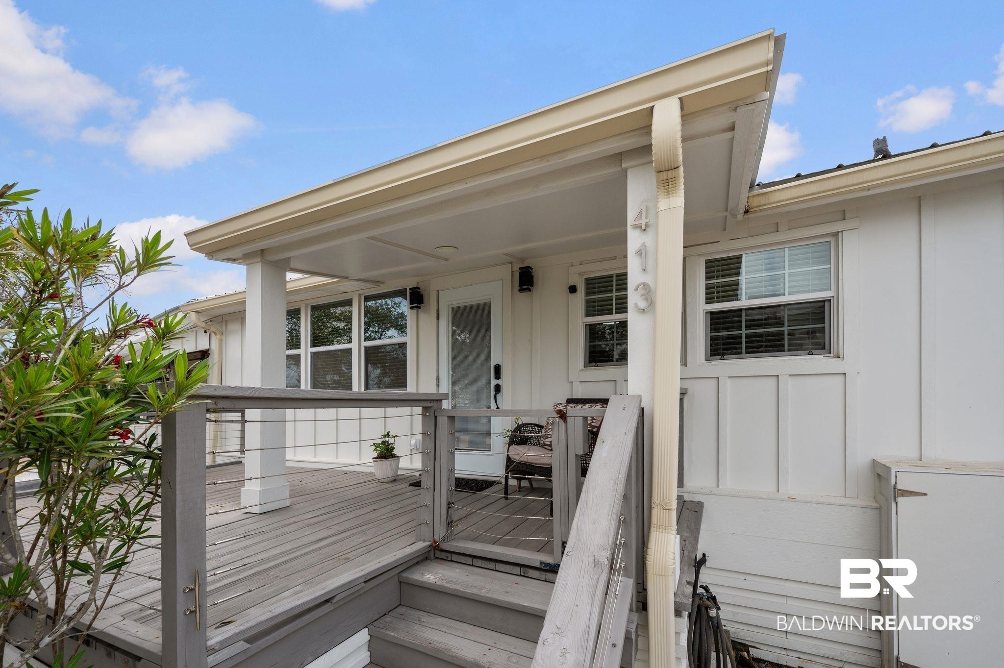 Image 2: Property entrance with board and batten siding and a deck