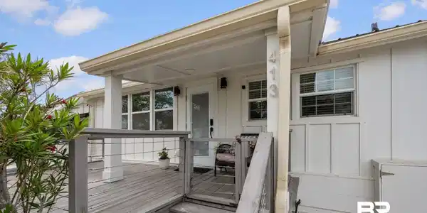 Image 2: Property entrance with board and batten siding and a deck