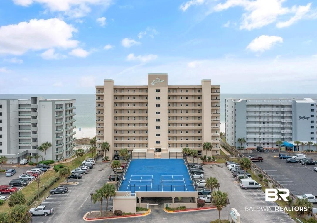 Image 1: Coastal high-rise property featuring private balconies, an on-site tennis court, ample parking, and immediate beach access