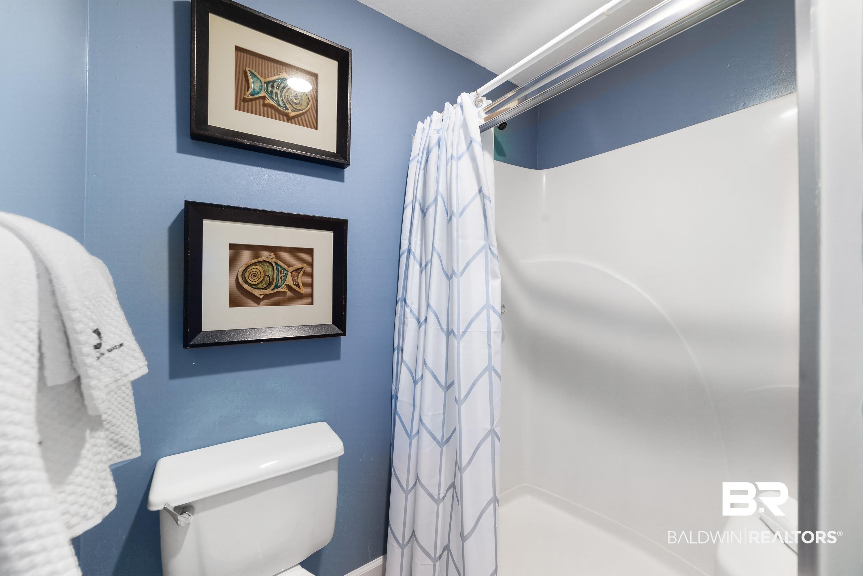 Image 3: White fiberglass shower with an integrated seat and a blue painted wall