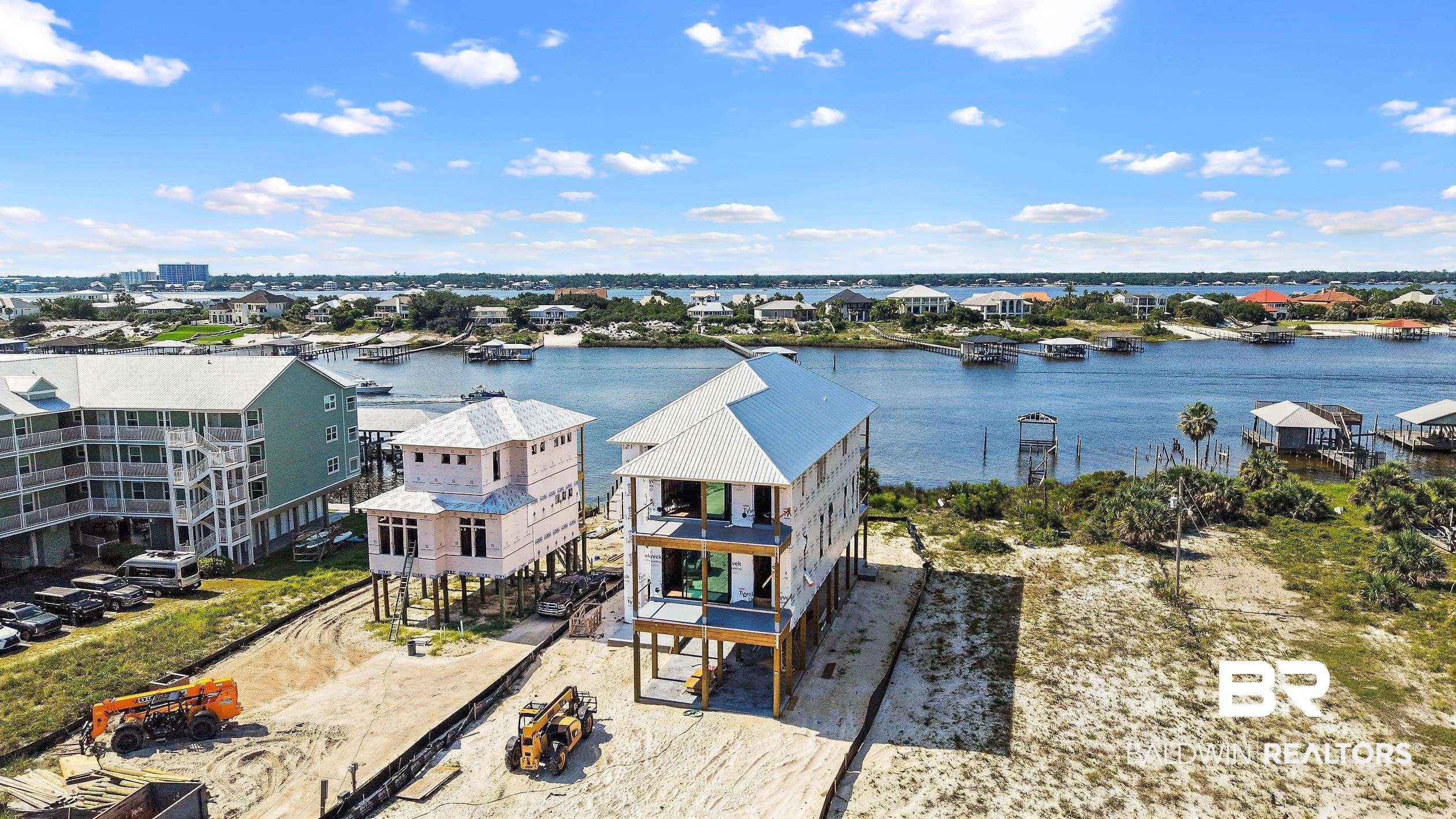 Image 2: Waterfront property with a multi-level structure featuring a metal roof and multiple balconies