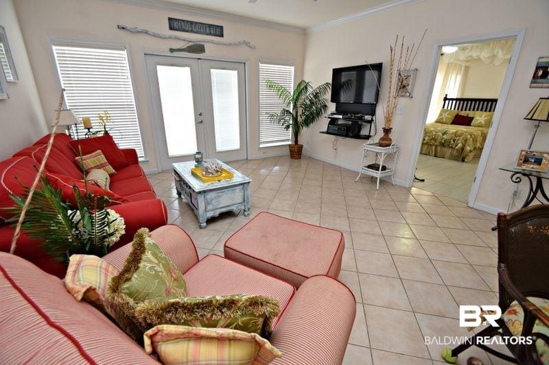 Image 3: Living area featuring light tile patterned floors, ornamental molding, french doors, and baseboards