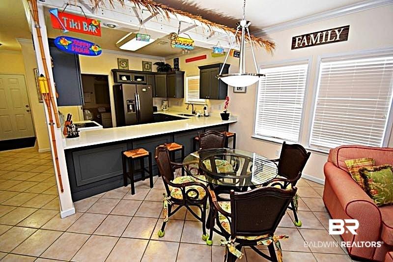 Image 4: Dining space with ornamental molding, light tile patterned floors, and baseboards