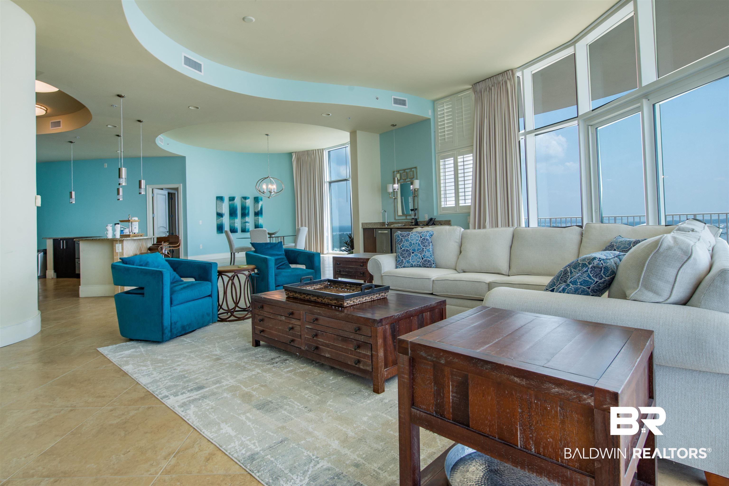 Image 4: Living room with light tile patterned floors and a chandelier