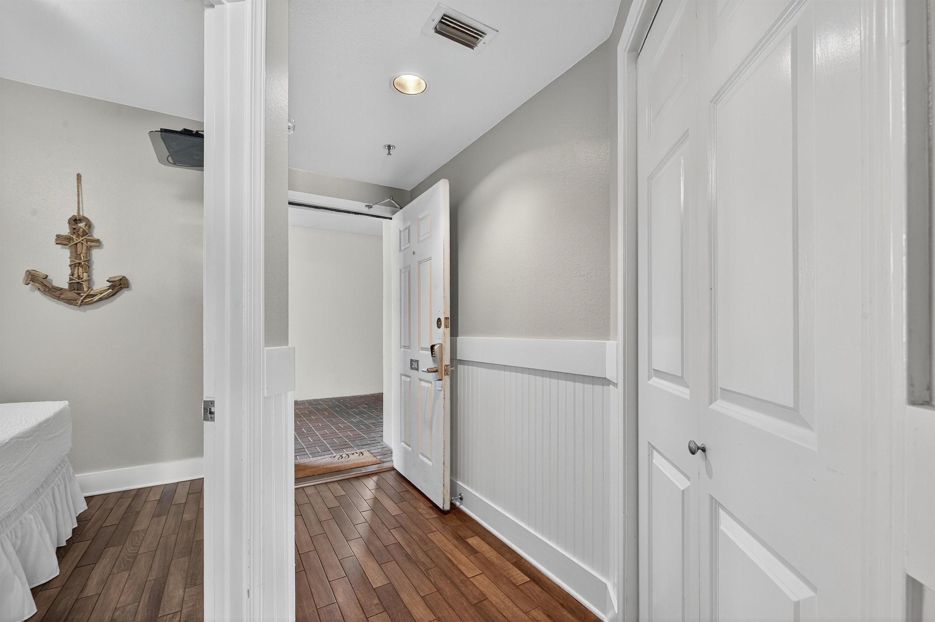 Image 4: Plank tile flooring leads into primary bedroom.