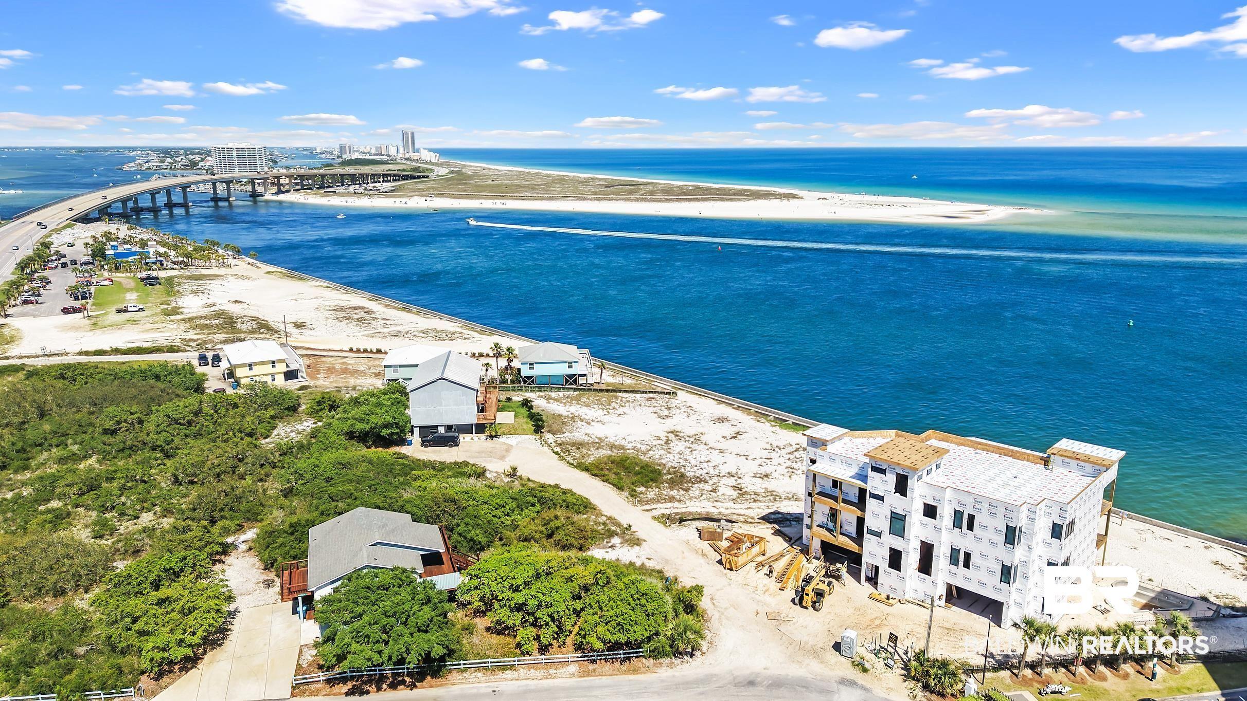 Image 3: Coastal property featuring a multi-story structure under construction, surrounded by natural vegetation