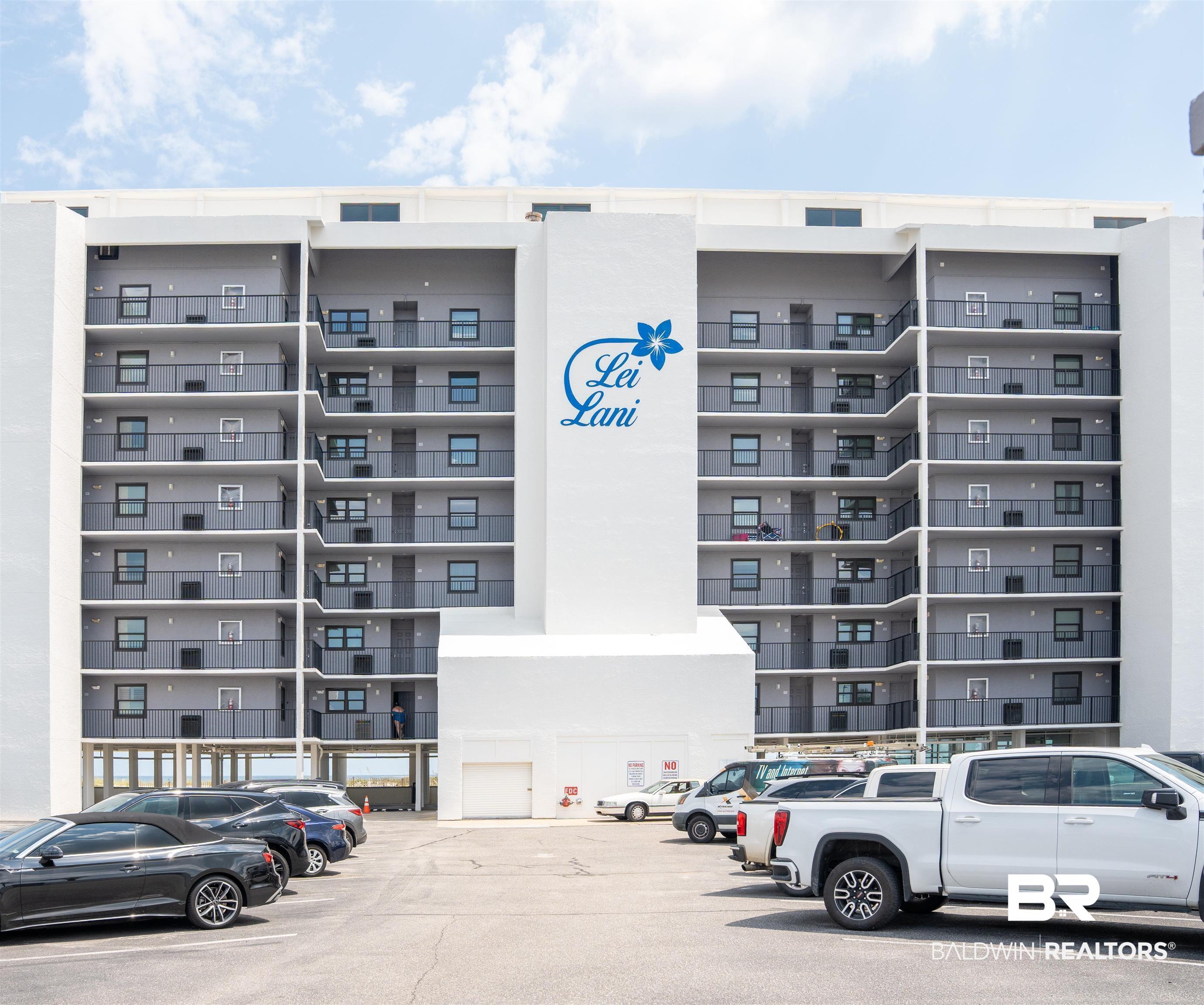 Image 1: Multi-story building featuring stacked balconies with dark railings, a prominent central white facade with "Lei Lani" branding, and a ground-level parking area