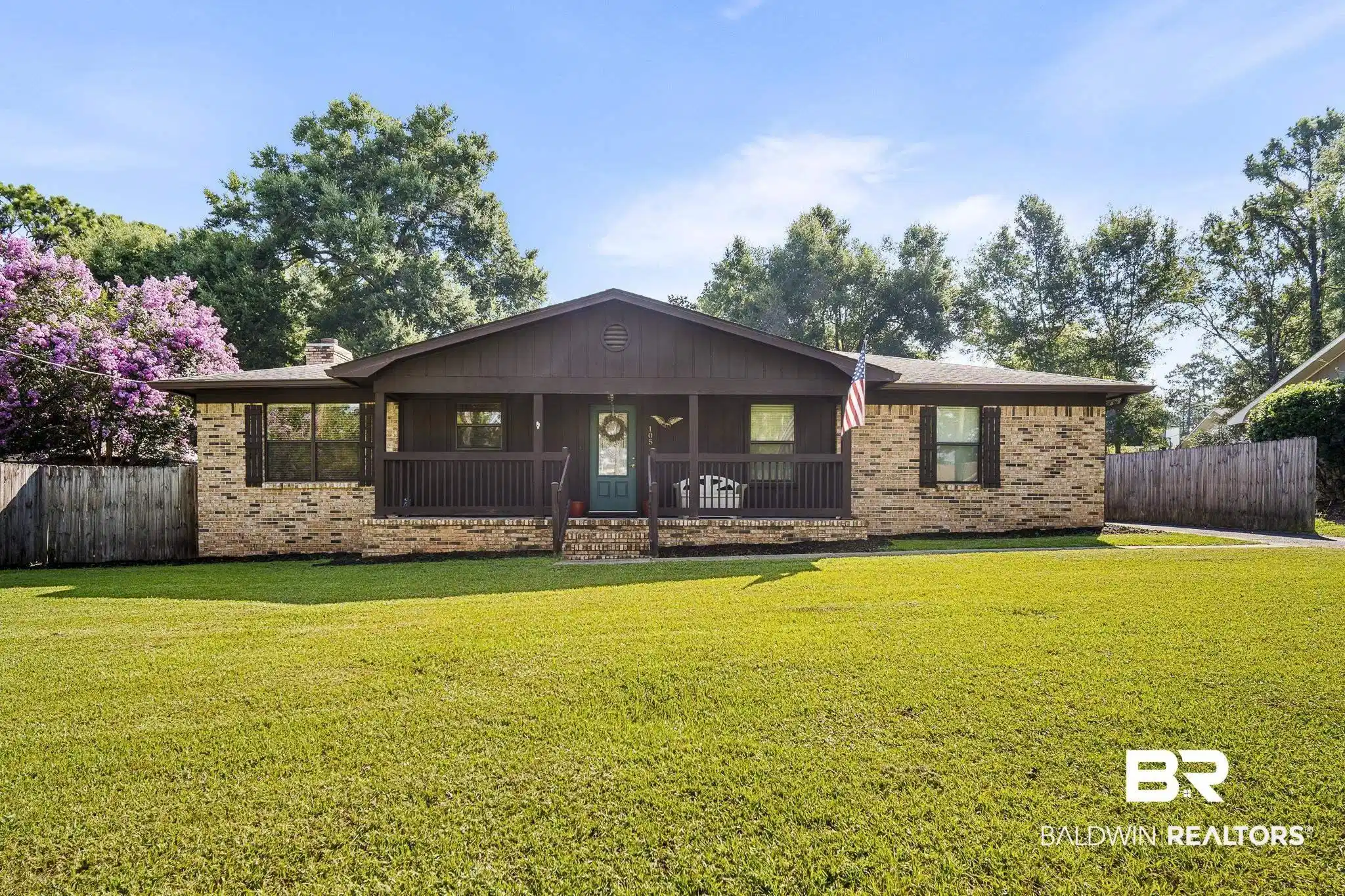 Image 1: Brick exterior with a dark brown trim and covered front porch
