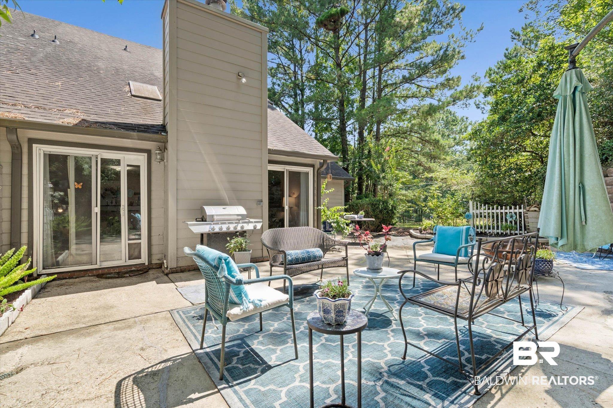 Image 2: Expansive concrete patio featuring multiple seating areas and direct access to the interior via sliding glass doors
