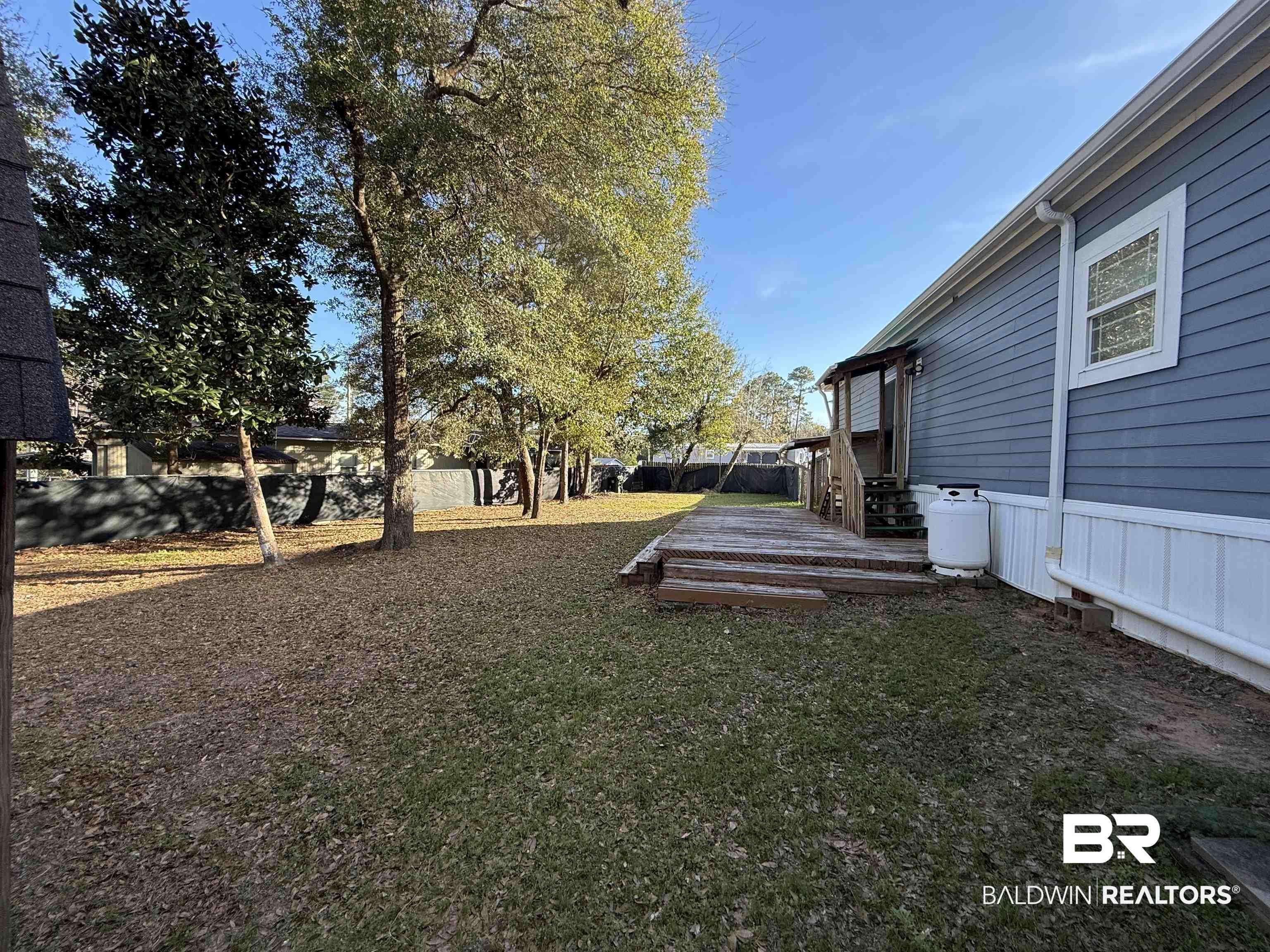 Image 3: Fenced yard with a deck