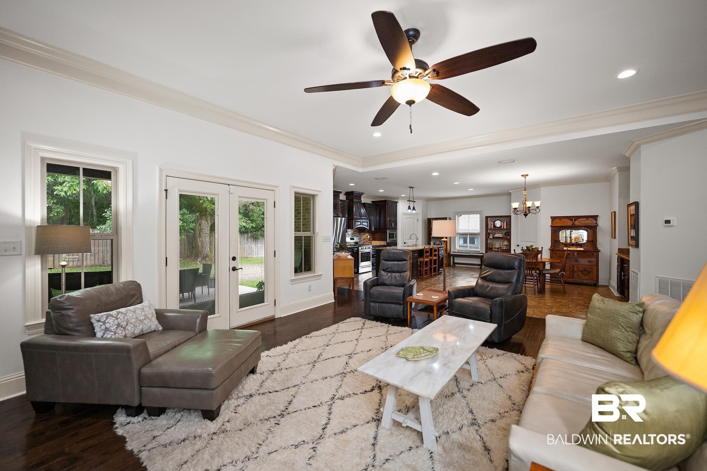 Image 3: Living area featuring dark wood-finish flooring, white walls, and a ceiling fan