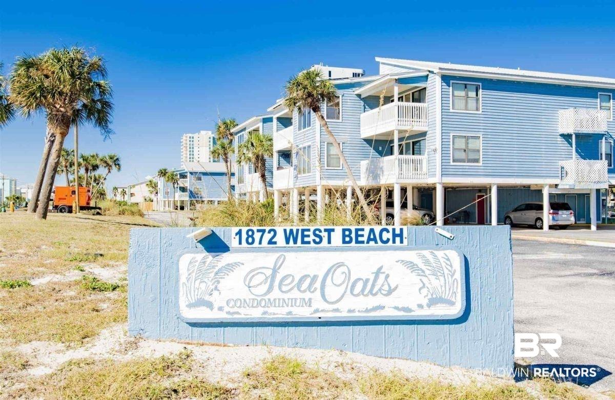 Image 1: "Sea Oats Condominium" signage featuring a light blue finish, white lettering, and palm tree accents