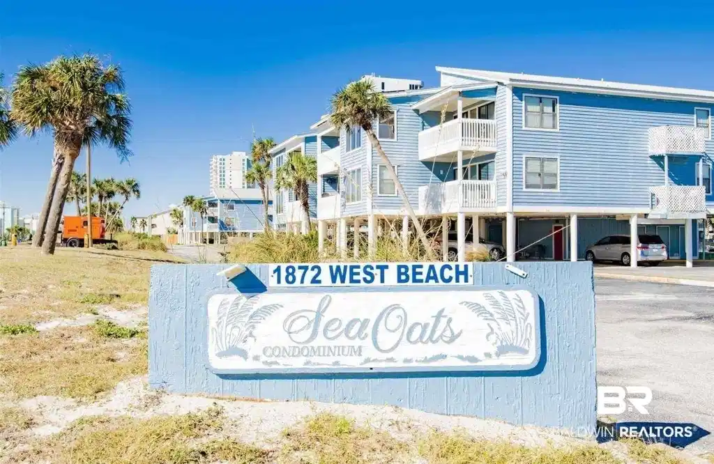 Image 1: "Sea Oats Condominium" signage featuring a light blue finish, white lettering, and palm tree accents