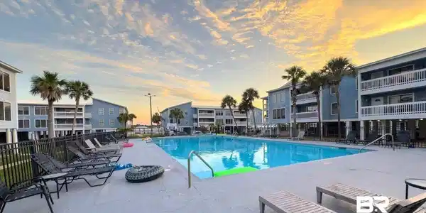 Image 2: Large outdoor swimming pool surrounded by a concrete deck
