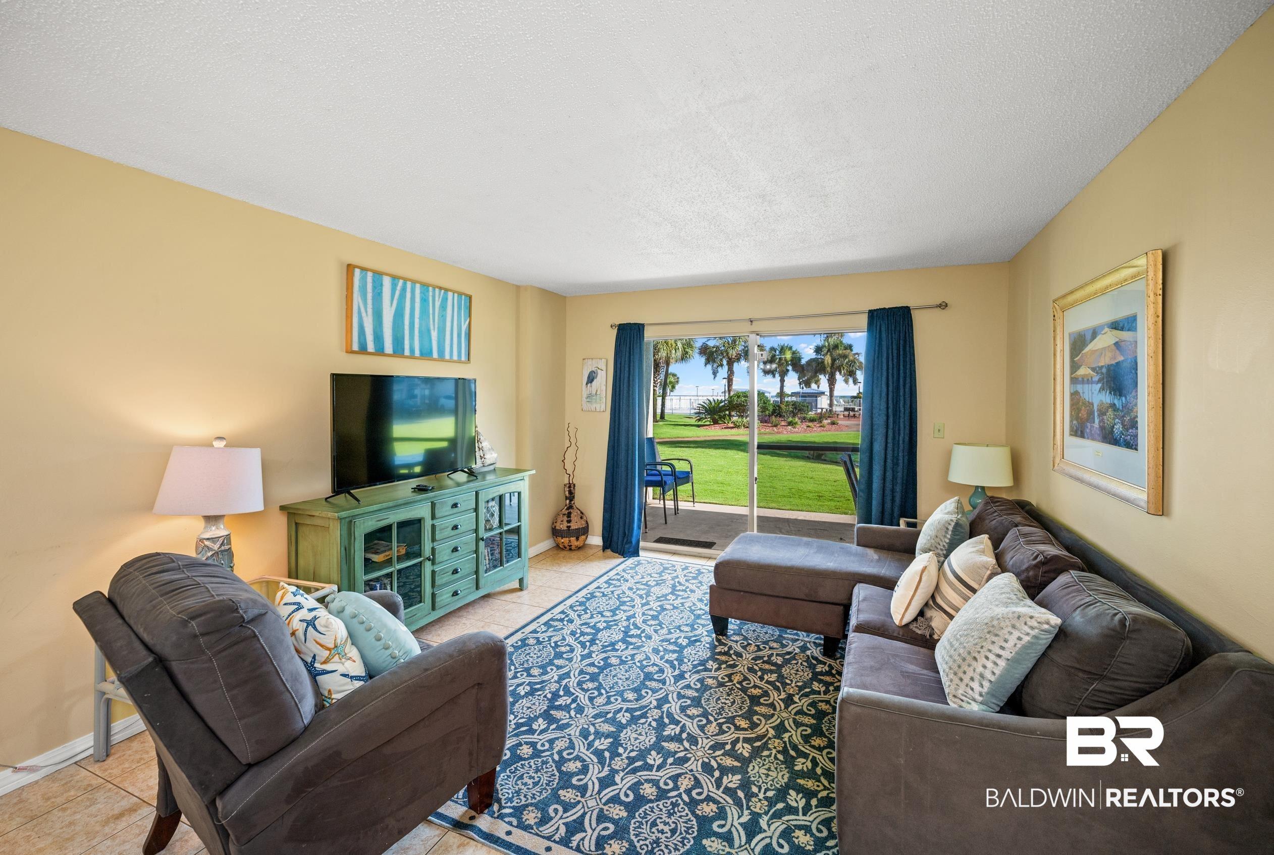 Image 4: Living area with tile patterned floors and a textured ceiling