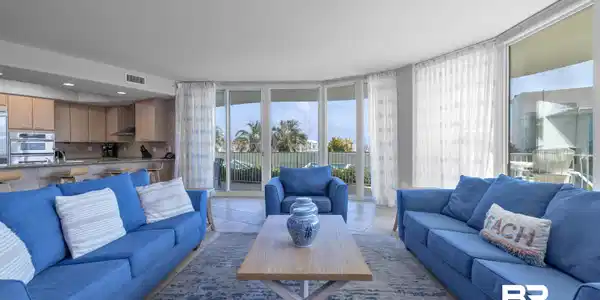 Image 2: Living room with healthy amount of natural light, light tile patterned floors, and floor to ceiling windows