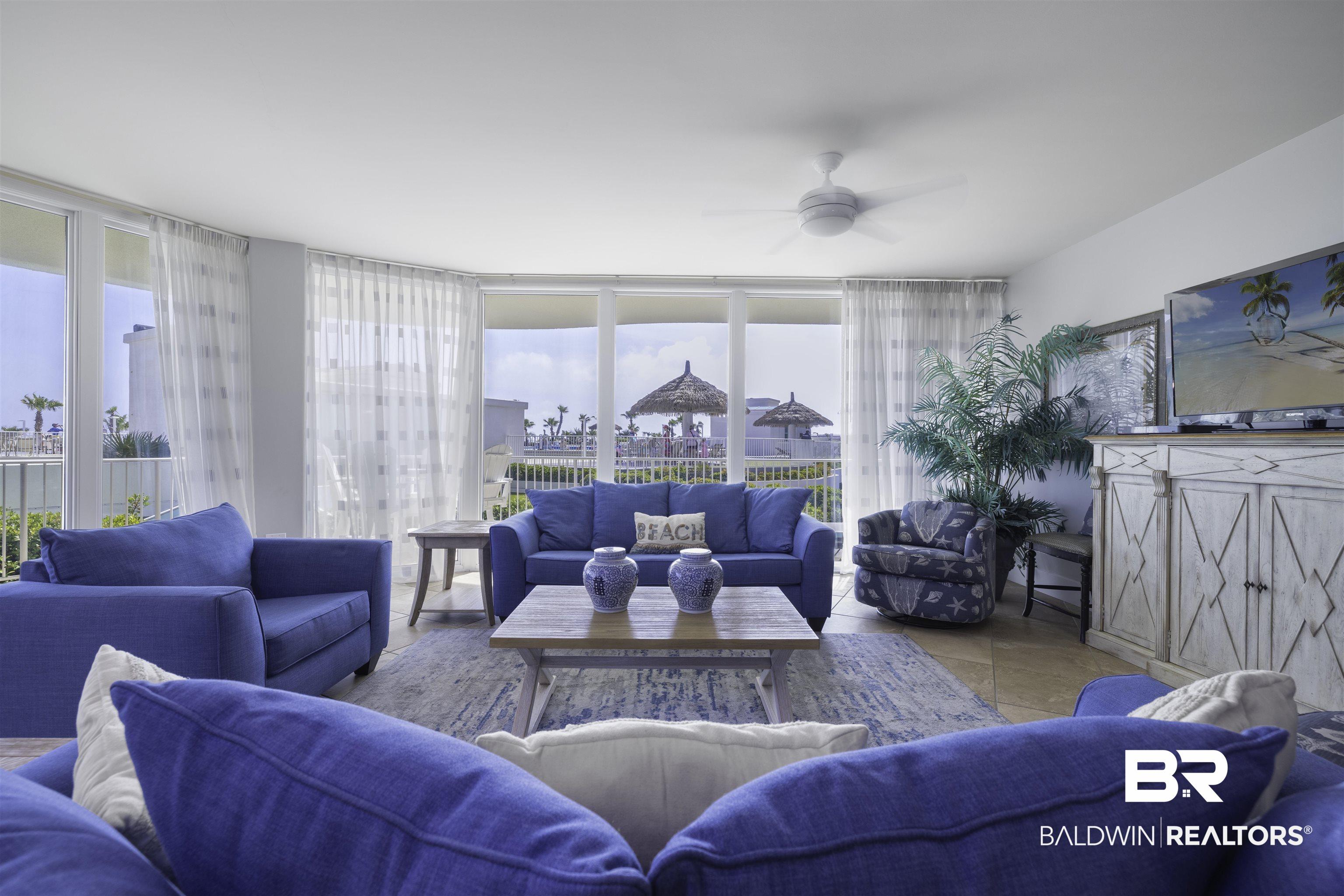 Image 3: Living area with ceiling fan and expansive windows
