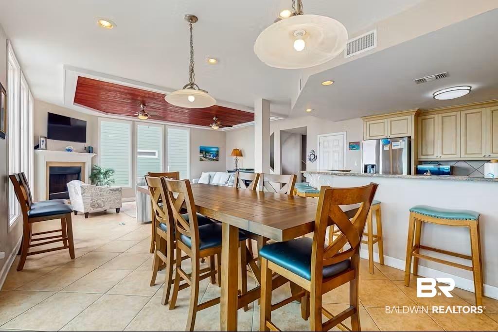 Image 4: Dining area featuring light tile patterned floors, a fireplace, recessed lighting, and ceiling fan