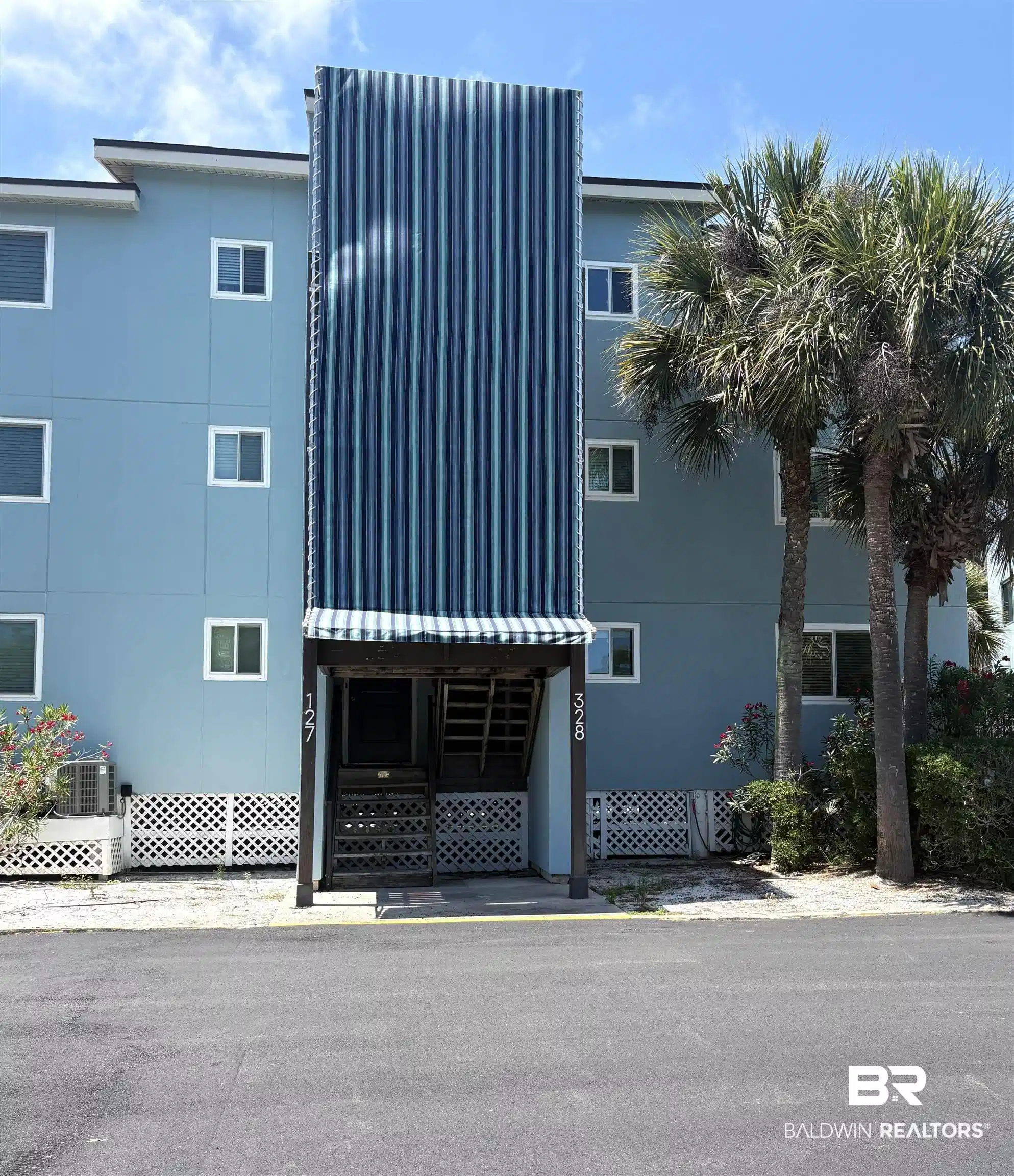 Image 1: Blue multi-story building featuring multiple windows and a prominent striped awning